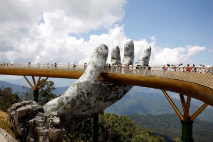 Tourists walk past giant hand structure on the Gold Bridge on Ba Na hill near Danang City, Vietnam August 1, 2018. REUTERS/Kham TPX IMAGES OF THE DAY