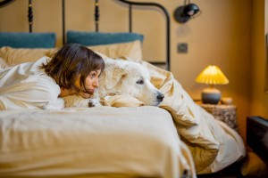 Woman with her dog lying on bed